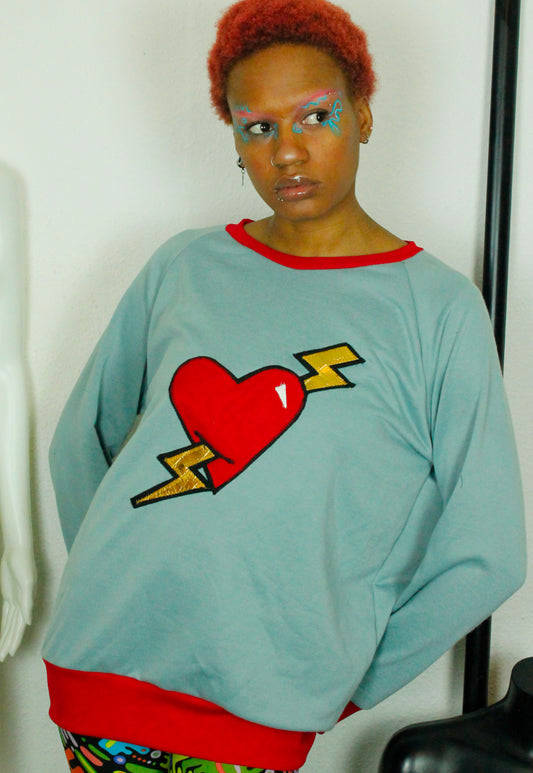 LOVE HURTS Baby blue oversize sweater with large heart and lightning bolts